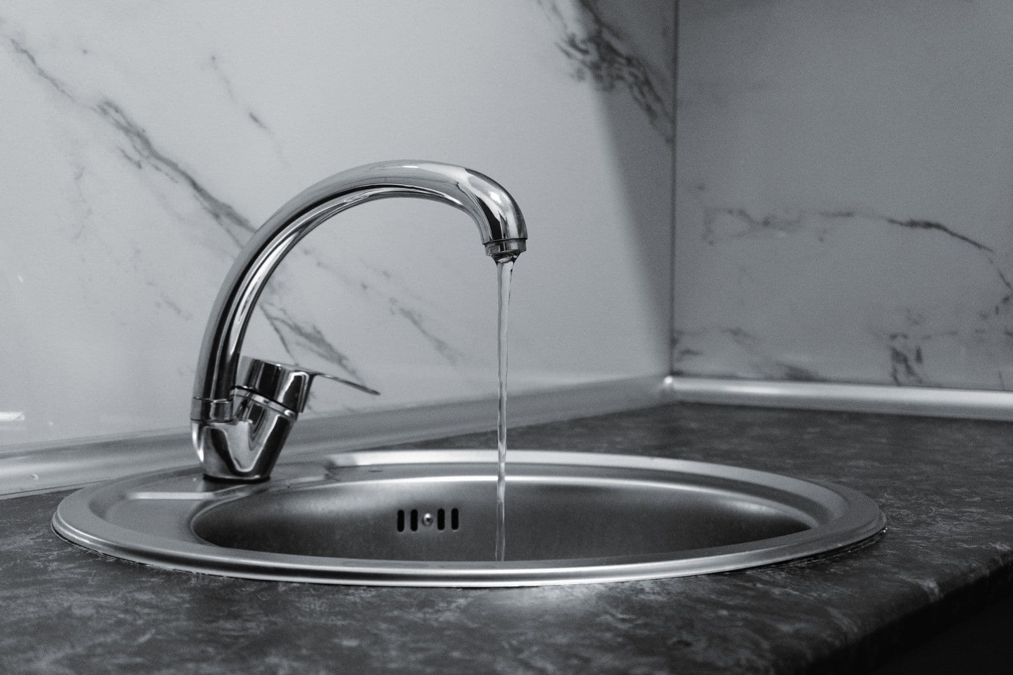 Water running from a chrome kitchen faucet